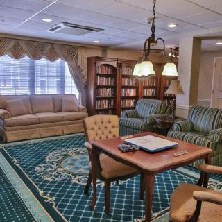 A cozy living room with a library featuring comfortable seating and bookshelves.