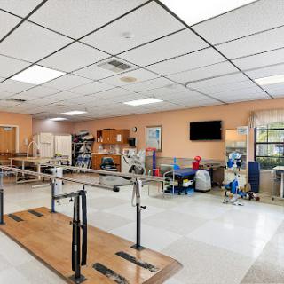 A spacious physical therapy room equipped with rehabilitation tools and exercise areas.