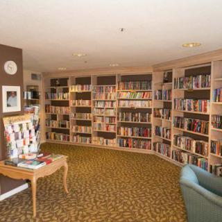 A cozy library corner with bookshelves filled with books and a comfortable armchair.