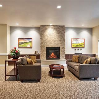 A cozy living room with sofas and a fireplace.