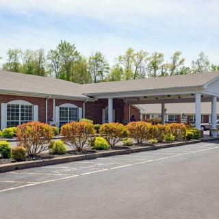 A well-maintained hotel building with a landscaped entrance and parking area.