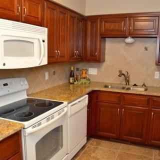 A modern kitchen showcasing wooden cabinets and essential appliances.