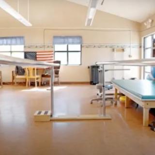A bright and spacious physical therapy room equipped with various exercise and rehabilitation tools.