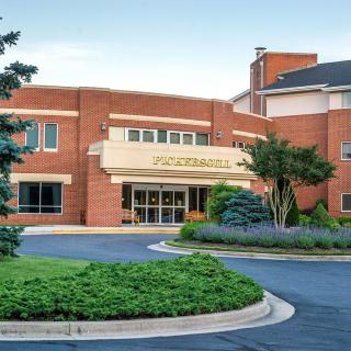 A hospital entrance surrounded by landscaped greenery and a circular driveway.