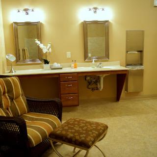 A well-designed bathroom featuring a vanity area with two mirrors and comfortable seating.