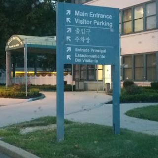 Signage indicating the main entrance and visitor parking area.