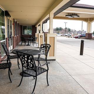 Empty outdoor seating area in a shopping center with metal tables and chairs.