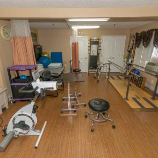 A physical therapy room equipped with various exercise machines and rehabilitation tools.