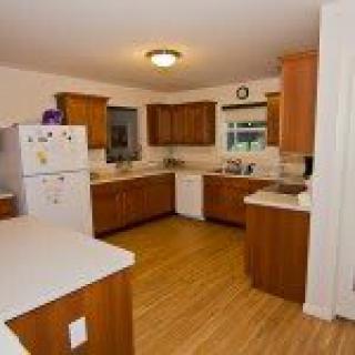 A spacious kitchen with wooden cabinets and modern appliances.