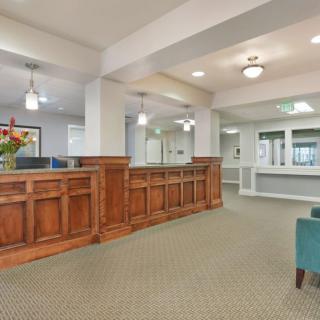 A spacious and elegant reception area with wood paneling and comfortable seating.