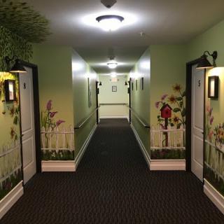 A well-decorated hallway featuring green walls and floral murals.