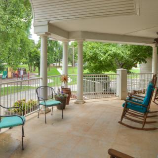 A cozy porch with rocking chairs and a view of the garden.