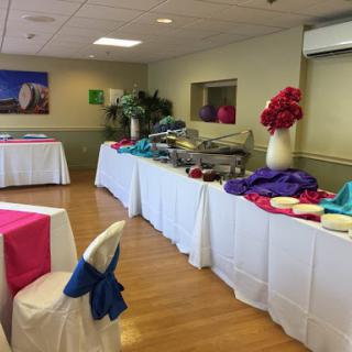 A well-decorated event space featuring colorful table linens and a food station.