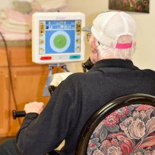 An elderly person exercises using a digital rehabilitation machine.