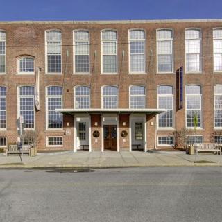 A historic brick building with large windows and an inviting entrance.