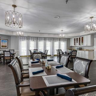 A modern dining room with neatly arranged tables and chandeliers.