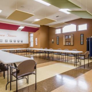 An empty conference room with arranged tables and chairs, ready for a meeting.