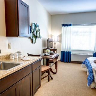 A cozy bedroom with a kitchenette and stylish decor.