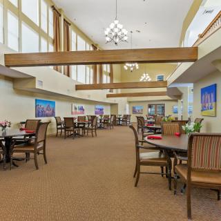 A spacious and well-lit dining area with tables and chairs arranged neatly.