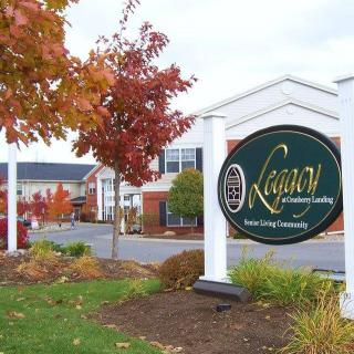 The entrance to a residential community with autumn foliage and well-maintained landscaping.