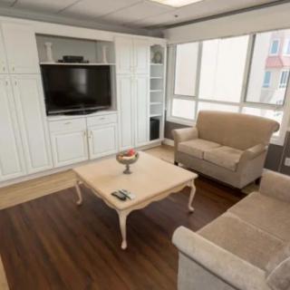 A cozy living room with a sofa, coffee table, and entertainment center featuring a TV.
