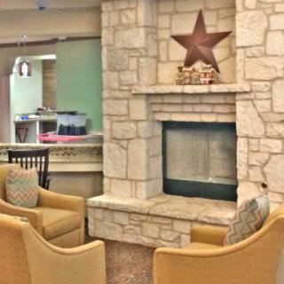 Cozy seating area with a stone fireplace and warm decor.