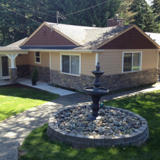 A suburban house with a fountain in the front yard.