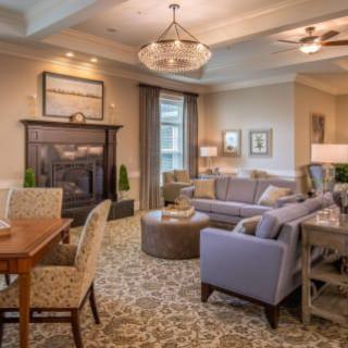 A cozy and elegantly designed living room with a fireplace, featuring a comfortable sofa, coffee table, and dining area.