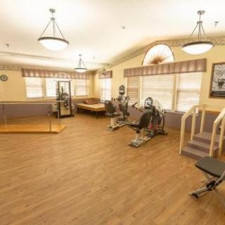 A spacious gym area equipped with various exercise machines, designed for rehabilitation and physical therapy.
