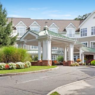 A modern building with a grand entrance and well-maintained landscaping.