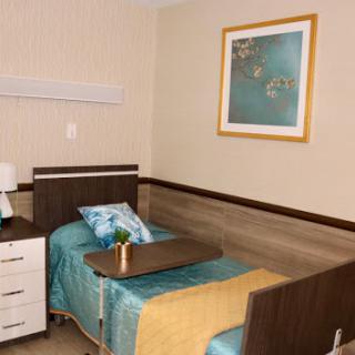A tidy and modern hospital room equipped with a patient bed and bedside amenities.