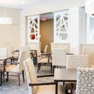 A modern dining area with patterned chairs and tables, featuring elegant lighting and decor.