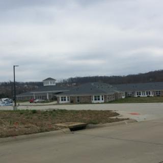 A cloudy day view of a residential building nestled in the hills.