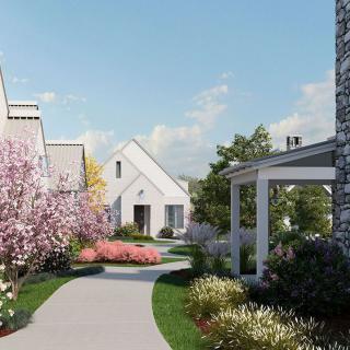 A picturesque residential area with a winding pathway surrounded by blooming flowers and trees.