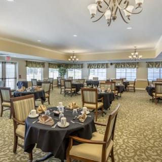 An elegant dining room setup with multiple tables and chandeliers.