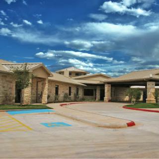 A modern building with a spacious entrance and vibrant sky.