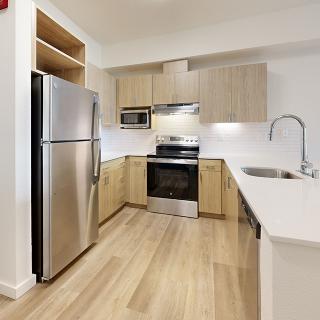 A modern kitchen with stainless steel appliances and wooden cabinets.