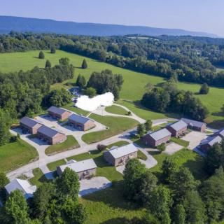 Aerial view of a campus surrounded by greenery and open fields.