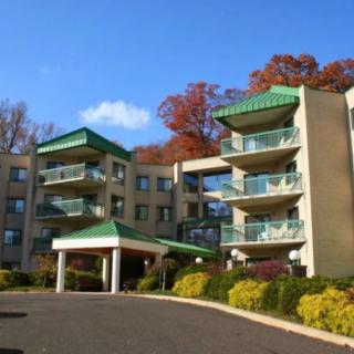 A residential apartment building with multiple balconies and landscaped surroundings.