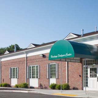 A brick building with a green awning over the entrance.