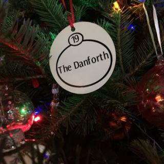 A Christmas tree ornament labeled 'The Danforth' hanging amidst colorful lights.