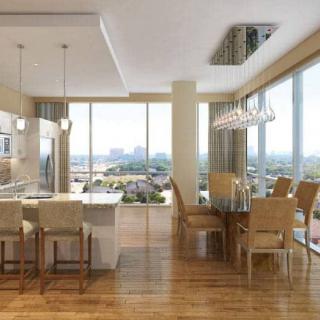 A modern open-plan kitchen and dining area with abundant natural light and a view of the city skyline.
