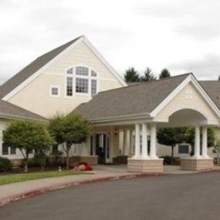 A well-maintained residential building with a covered entrance and ornamental columns.