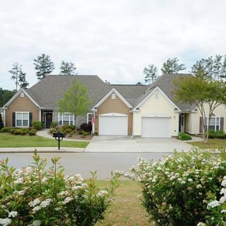 A suburban neighborhood with two attached houses, featuring driveways and landscaped yards.