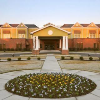 A stylish building entrance with a circular flower bed and pathway.