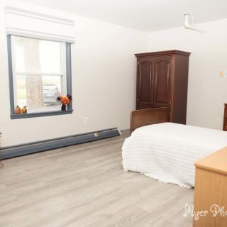 A minimalist bedroom with a bed, wardrobe, and window.