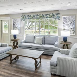 A cozy living room with light-colored sofas, a wooden coffee table, and decorative lamps.
