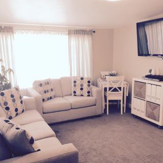 A cozy living room with sofas, a television, and a small dining area.