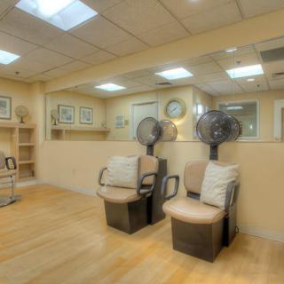 A tranquil hair salon interior with seating and hair dryers, ideal for a relaxing beauty treatment.