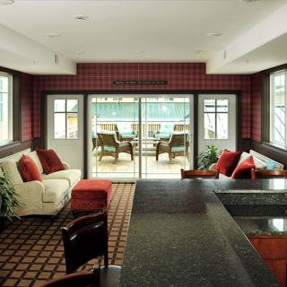 A modern living room with a view of the patio, featuring comfortable seating and stylish decor.
